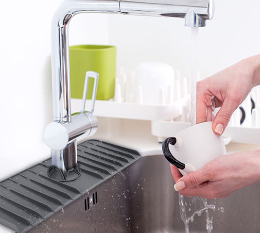 Rinsing a cup beside the silicone faucet drip catcher tray